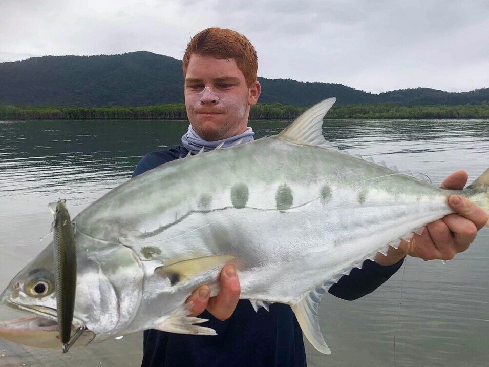 Man with reddish hair showing a large queenfish