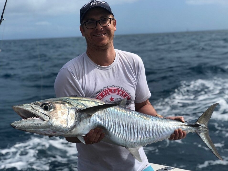 Game fisher presenting his spanish mackerel catch