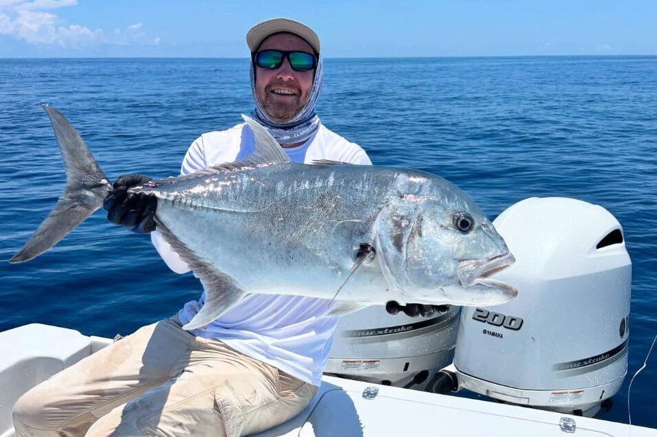 Fisherman with a freshly caught Giant trevally