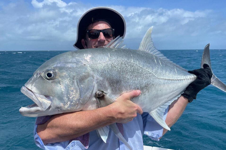 Angler holding a freshly caught Giant trevally