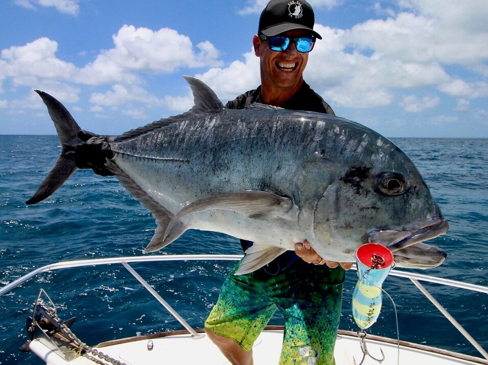 An angler with cap presenting his giant trevally at popper reef fishing