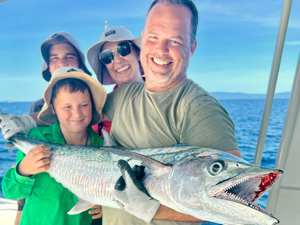 A family of anglers showing off their freshly caught Spanish Mackerel