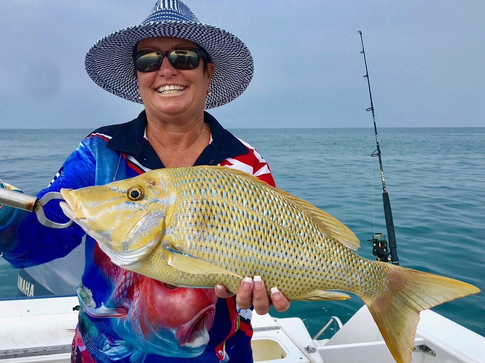 female angler holding a great barrier reef fish