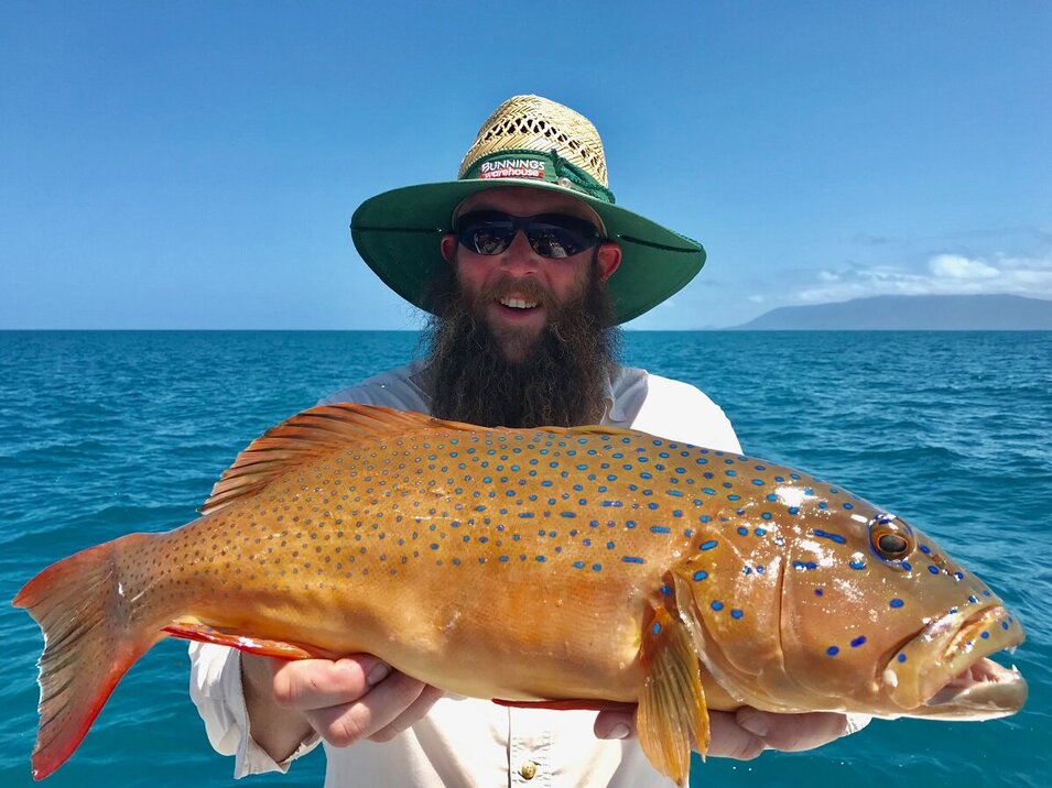 male angler with a beard presenting his coral trout catch