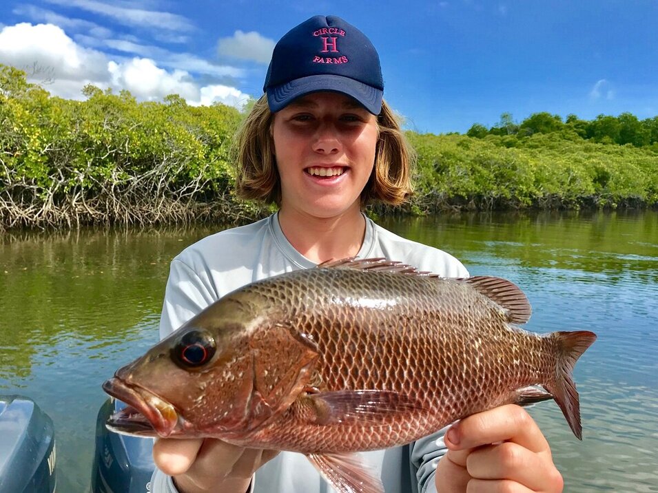 young male angler showing his mangrove jack catch