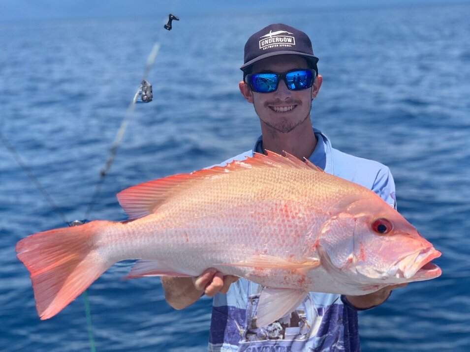 male angler holding a large reef fish