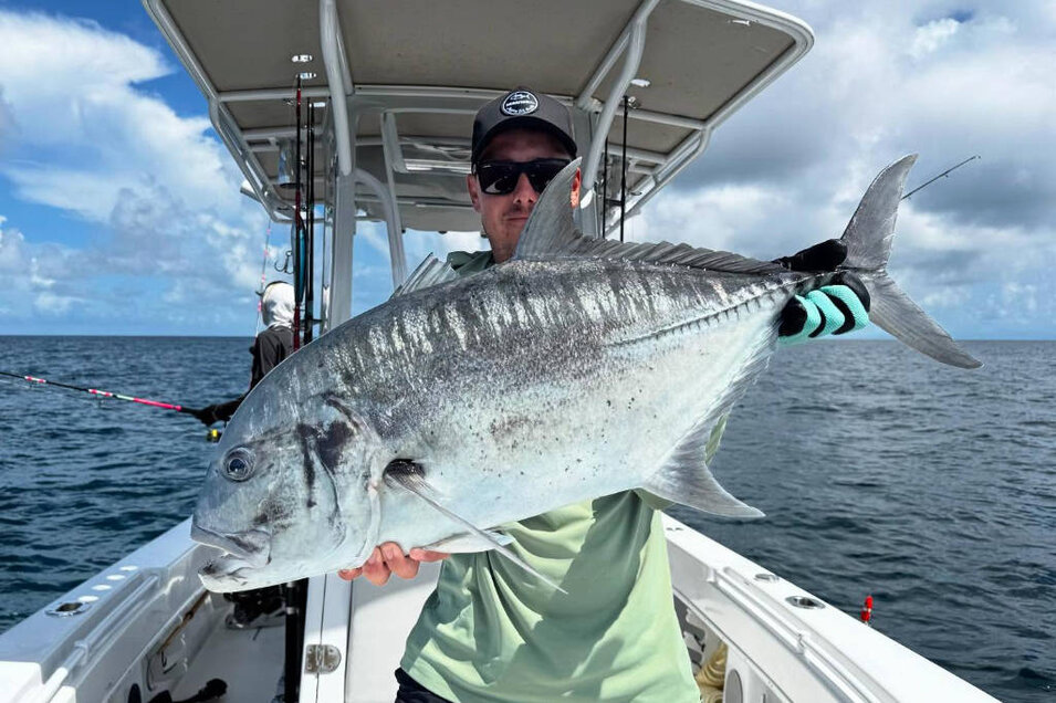 Fisherman with a freshly caught Giant trevally