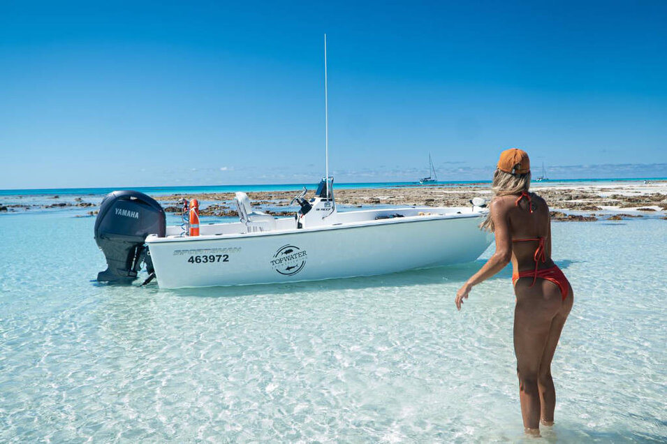 Topwater Sportfishing vessel moored off a tropical island with a lady
