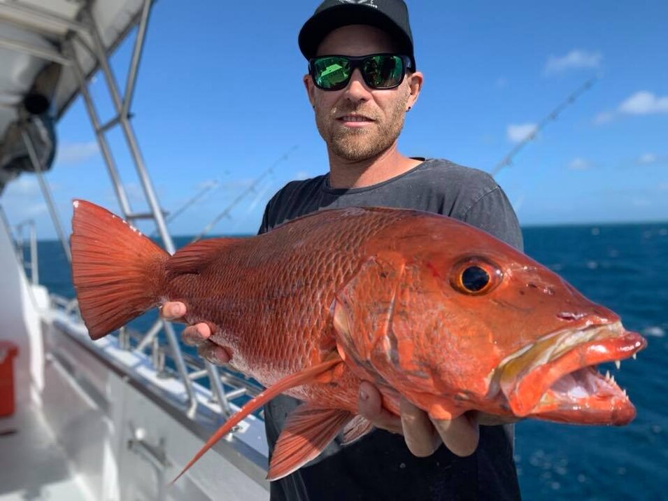 Male angler holding a red emperor fish