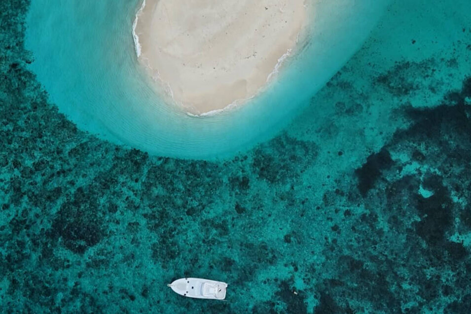 Aerial photo of the Ghost 40 foot OBrien vessel near a sand island on the Great Barrier Reef, Port Douglas