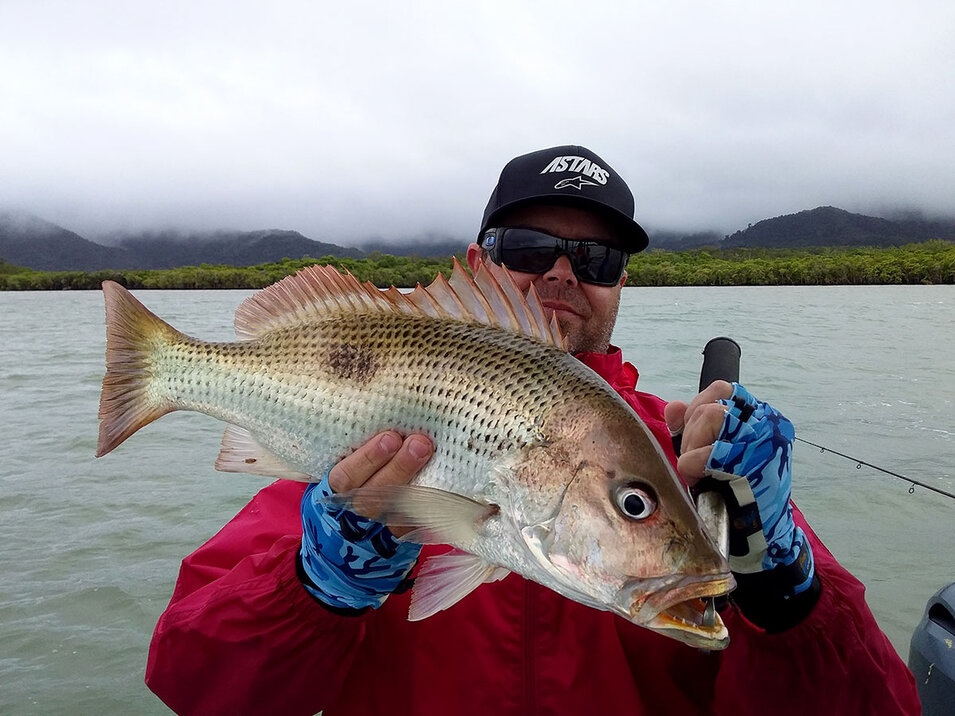 Angler holding a Mangrove Jack caught on On the Daintree Charters