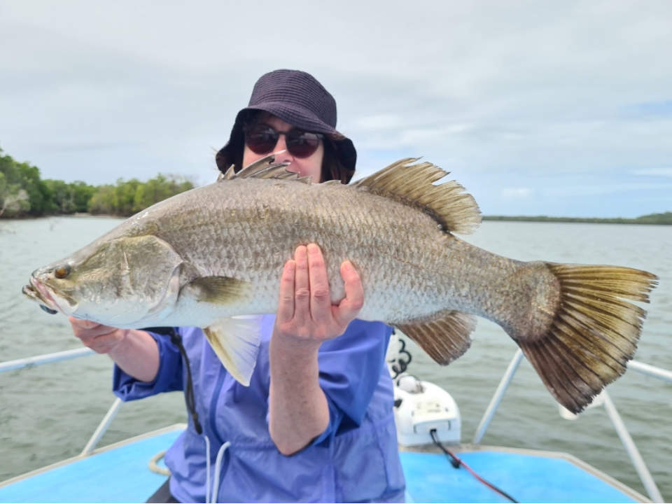 Angler holding a freshly caught Barramundi fish