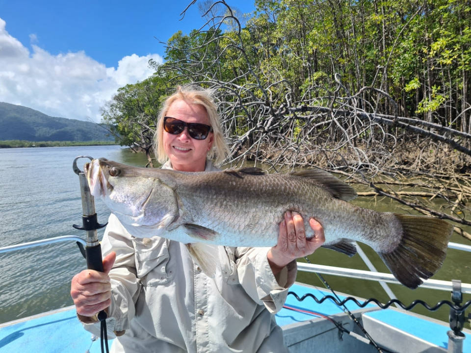 Angler holding a freshly caught Barramundi fish