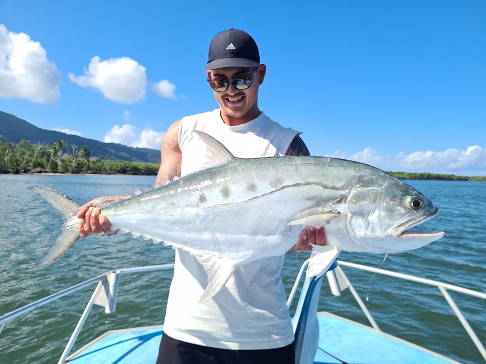 Angler holding up their catch of a Queenfish near the Daintree River