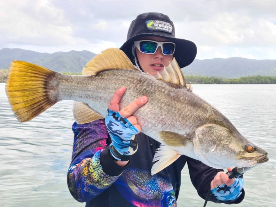 Angler holding a freshly caught Barramundi fish