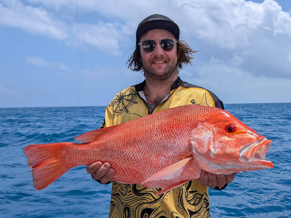 Fisherman holding a Nannygai fish