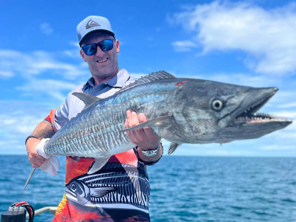 Angler holding a freshly caught Spanish mackerel