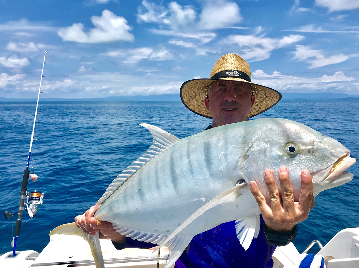 Reef angler holding a trevally fish