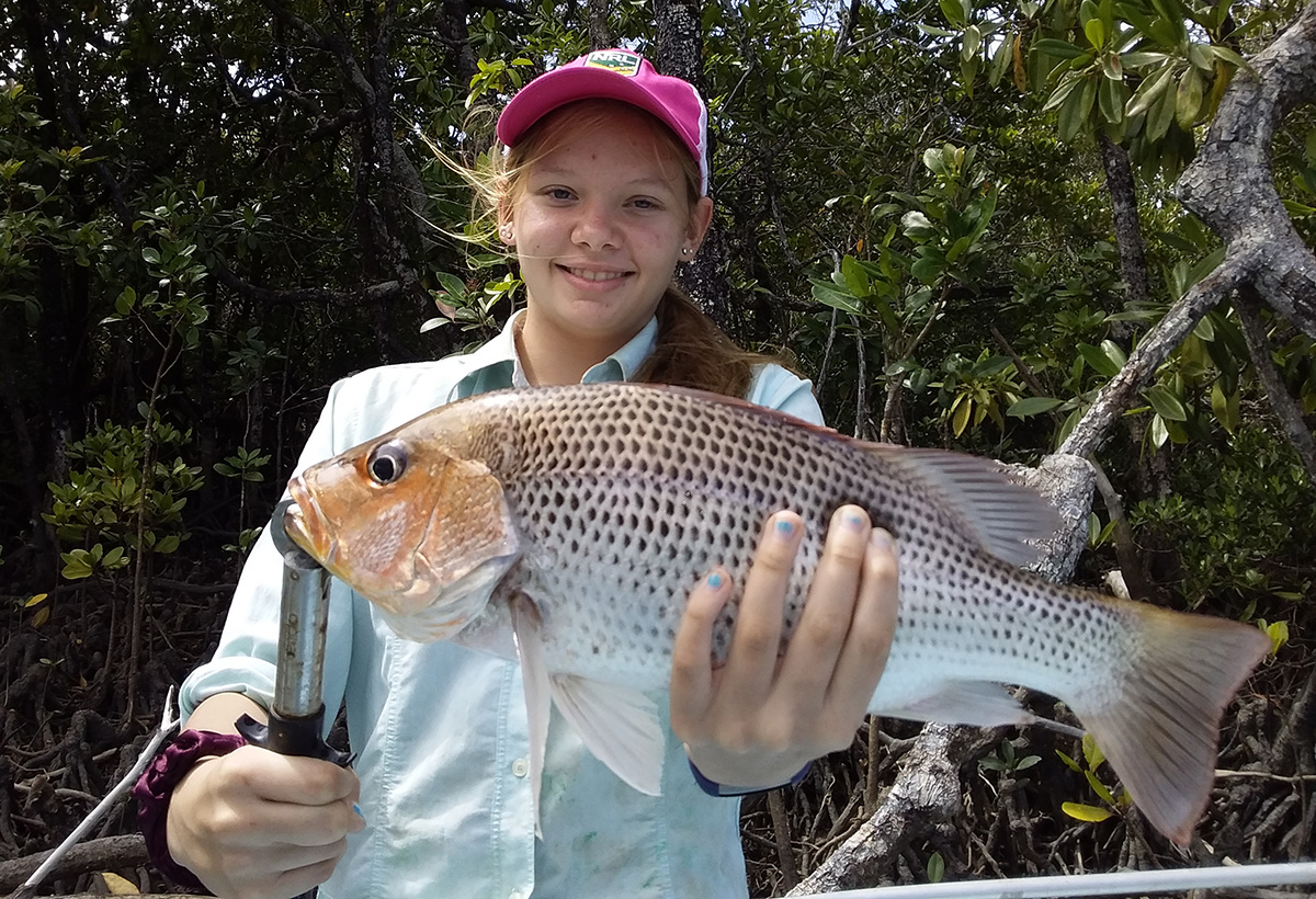 Young girl holding proudly a fingermark fish
