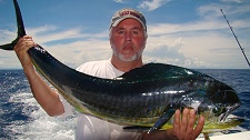 Game fisher with white beard holding a mahi mahi fish